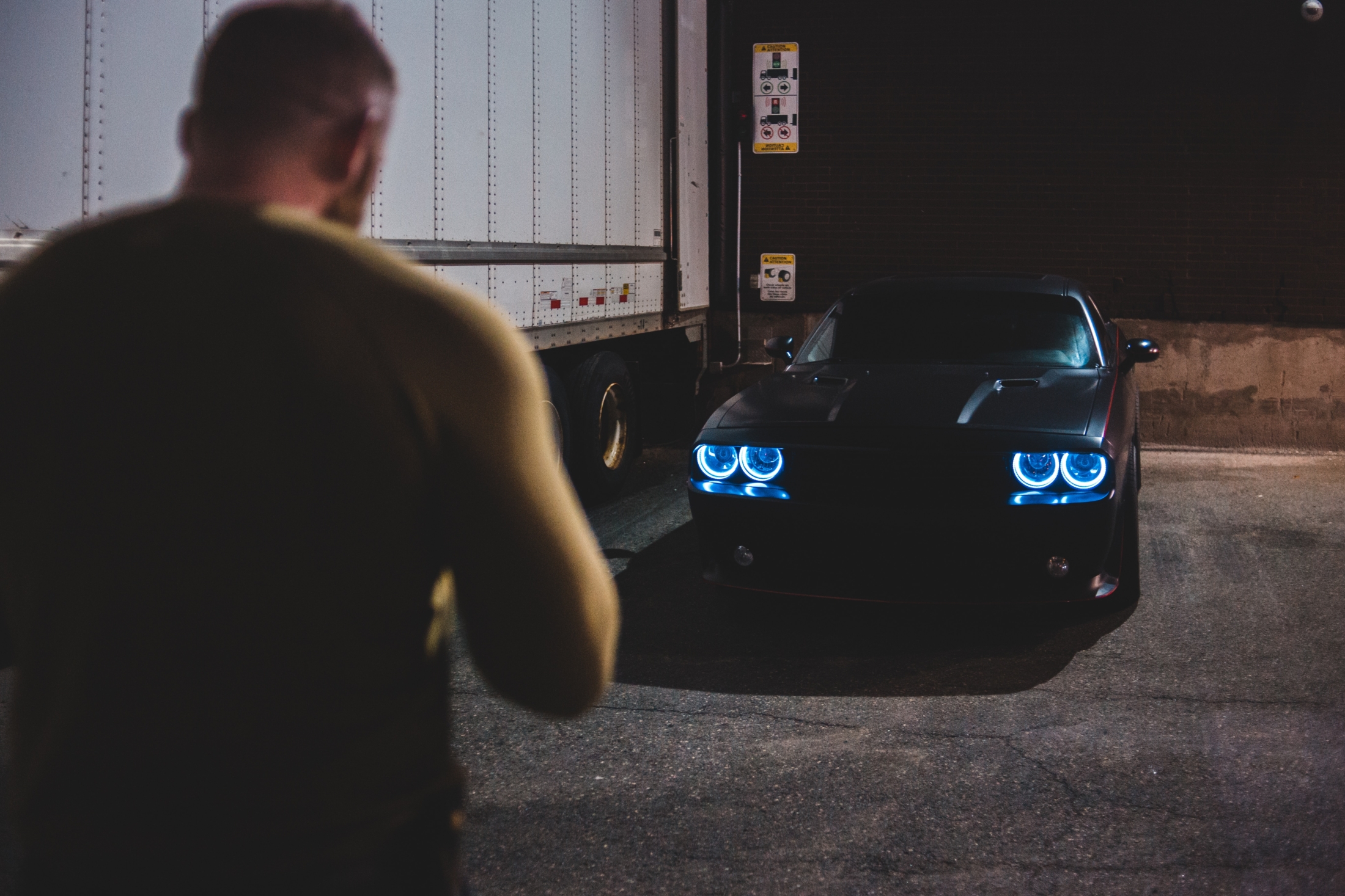 Man In Black T Shirt Standing Beside Blue Car During Nighttime